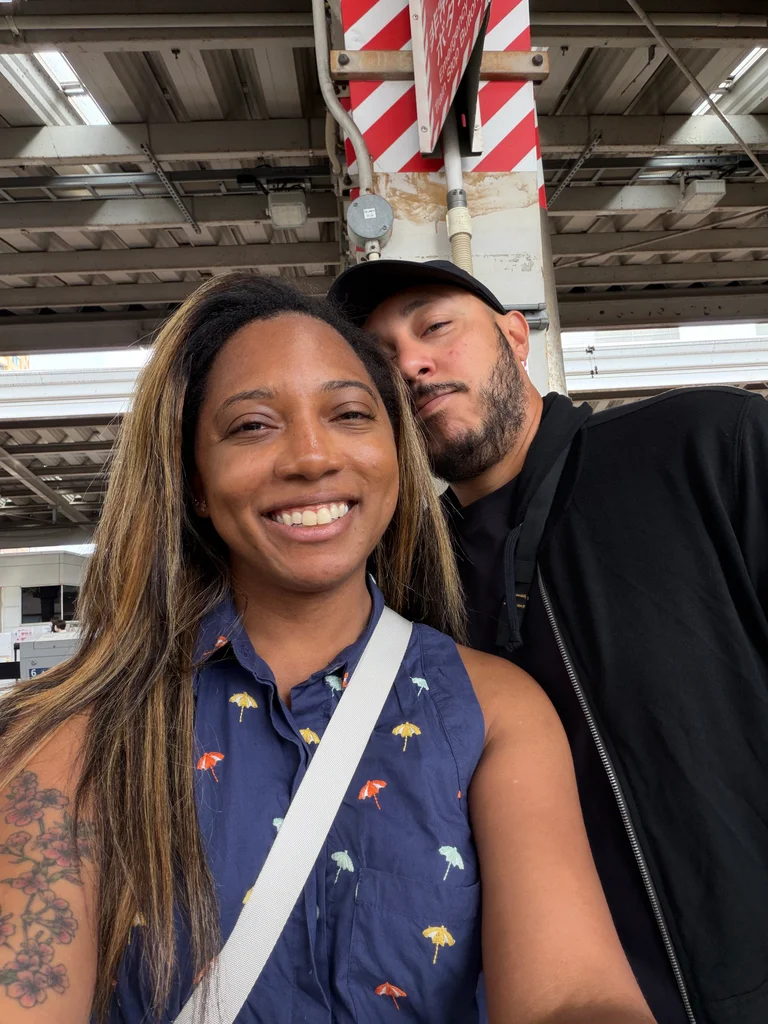 Jordan Lee and his wife taking a selfie beneath a metal-roofed shelter.